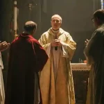 Cerimonia religiosa all'interno di una chiesa cattolica, con sacerdoti in paramenti sacri