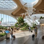 Viaggiatori in un luminoso terminal aeroportuale che illustra il design degli aeroporti moderni