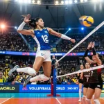 Azione su un campo di pallavolo femminile con giocatrice impegnata in una schiacciata