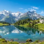 Una vista panoramica delle alpi con un lago alpino a simboleggiare lo spirito di una vacanza in Svizzera