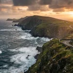 Una fotografia paesaggistica cinematografica e grandangolare della frastagliata costa irlandese lungo la Wild Atlantic Way durante il tramonto.