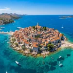 Una vista aerea mozzafiato, scattata con un drone durante una soleggiata giornata estiva, della penisola di Primosten, in Croazia.