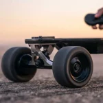 Primo piano della parte anteriore di uno skateboard elettrico con una mano che regge il telecomando per la guida