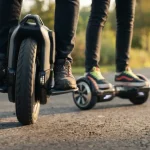 Primo piano di hoverboard e monoruota su strada con persone a bordo
