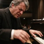 Un pianista in un concerto durante una interpretazione musicale sofferta e partecipata.