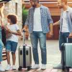 Famiglia che carica valigie in auto per viaggio estivo