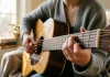 Una persona che impara a suonare la chitarra da autodidatta con i primi semplici accordi.