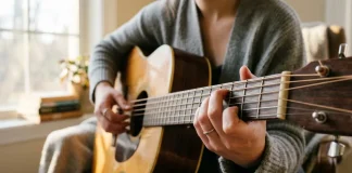 Una persona che impara a suonare la chitarra da autodidatta con i primi semplici accordi.