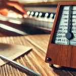 Metronomo che batte tempo musicale e mano di pianista che suona