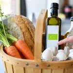 Cesto con prodotti bio come verdura, uova olio e pane