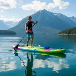 Persona che pratica SUP su un lago con una tavola gonfiabile colorata