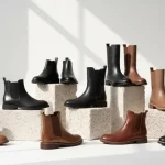 Foto editoriale di stivali e anfibi alla moda disposti su sfondo neutro