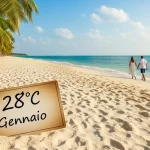 Vacanze invernali al caldo di coppia che cammina su una spiaggia mano nella mano con cartello 28°