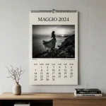 Un calendario fotografico d'autore su una parete di un appartamento moderno con cataloghi di grandi fotografi sul tavolino