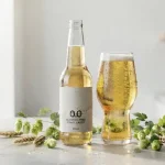 Una moderna bottiglia di birra analcolica con luppoli verdi freschi e spighe d'orzo intorno
